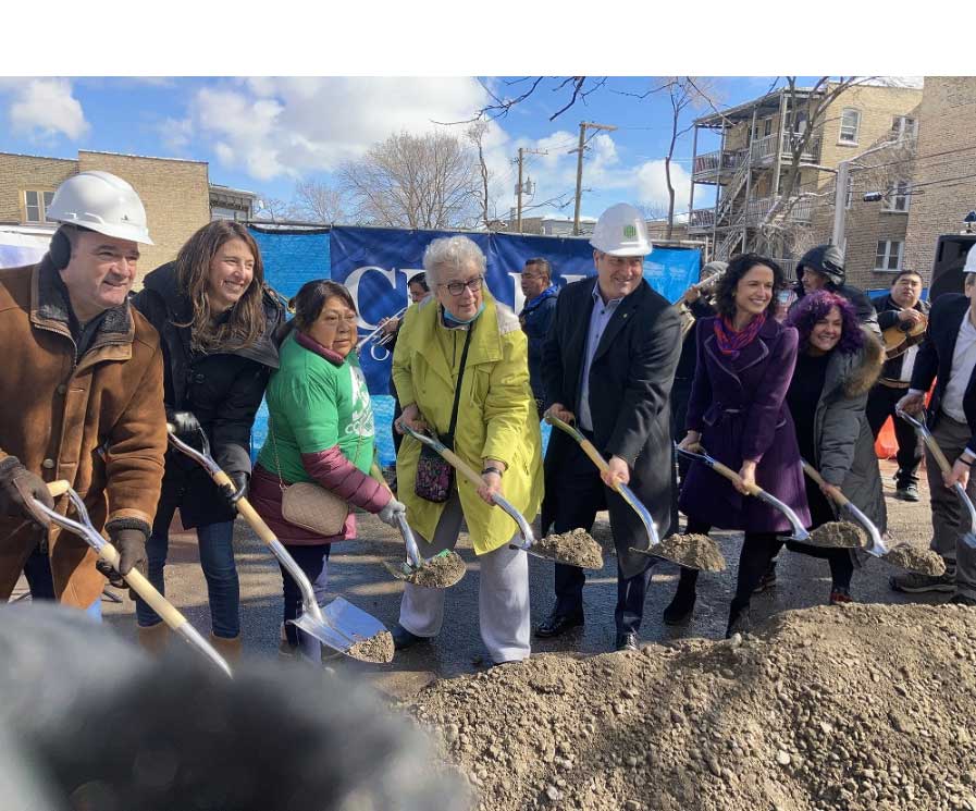Eight people holding dirt in shovels