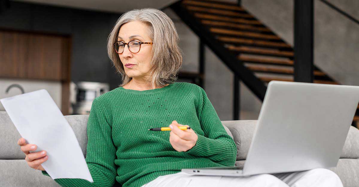 Woman sitting on couch with laptop.