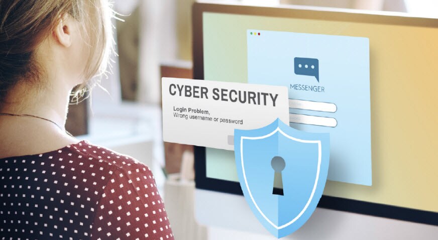 Woman at her computer with cyber security on the screen.