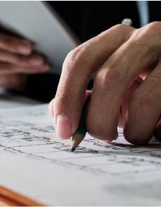 Hand making notations with a pencil.