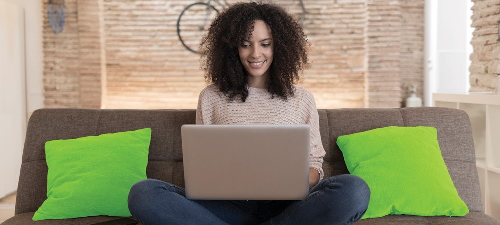 Woman sitting on couch on laptop