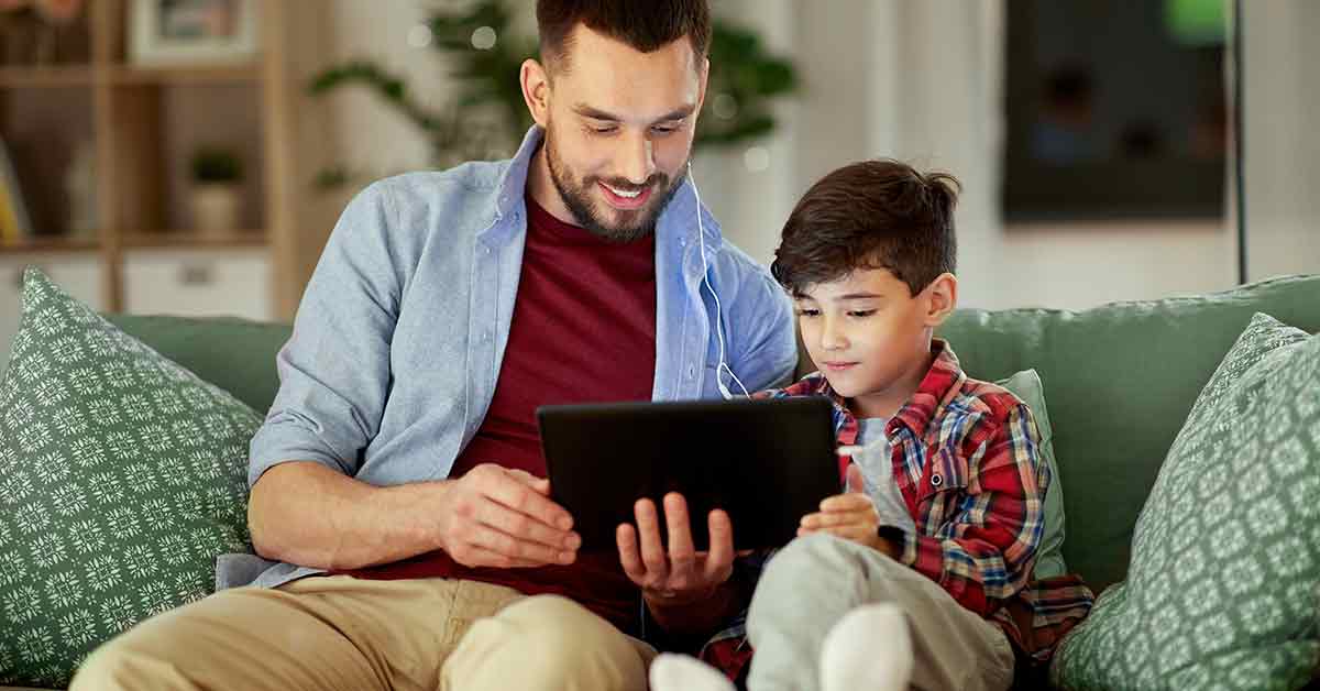A father instructing his son about money and spending on tablet.