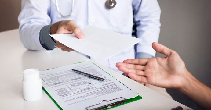 Doctor handing patient medical bill