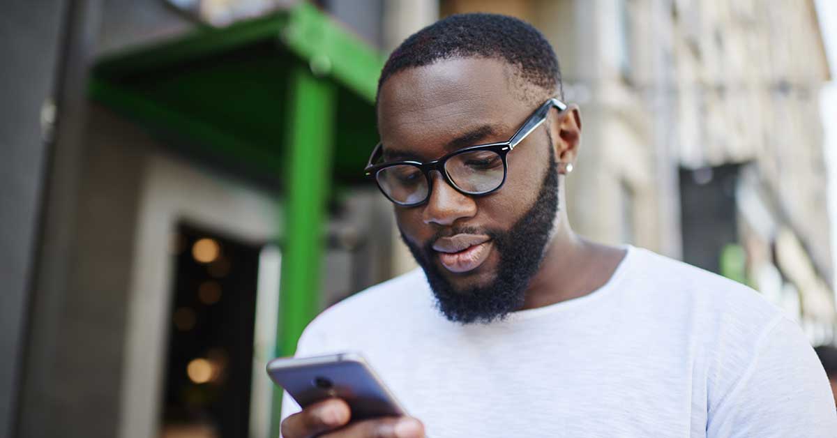 a young man looks at his account balance on his smartphone