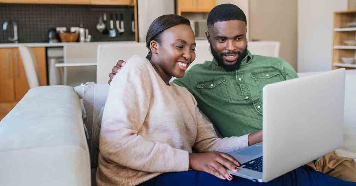 a couple looks at their checking account on a laptop