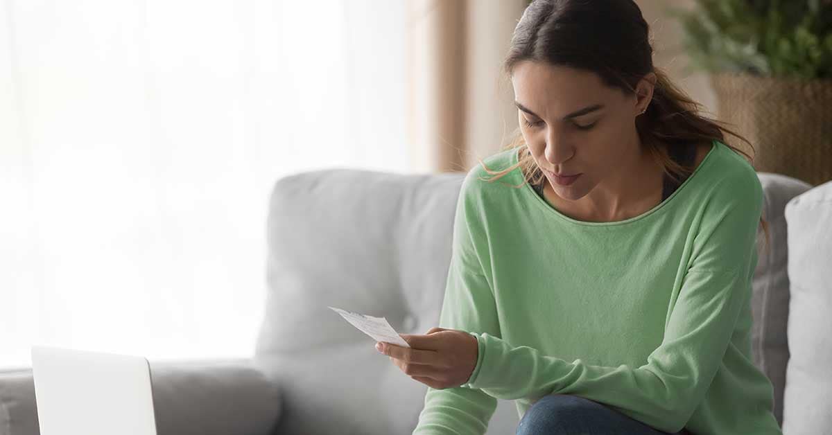 a young woman looks at the expiration date on a check