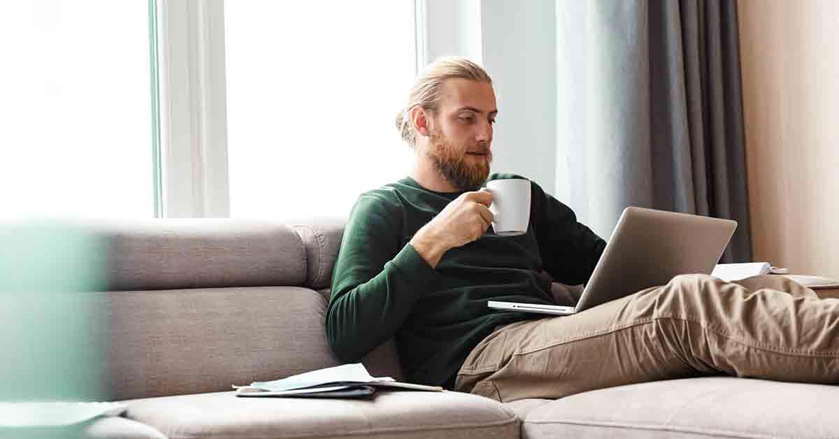 a young man researches how to open a checking account on his laptop