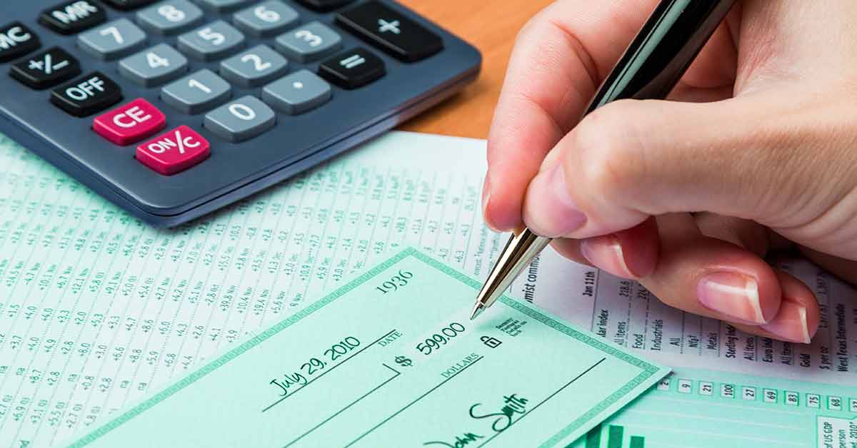 hand holding pen writing check