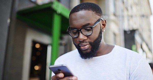 a young man looks at his account balance on his smartphone