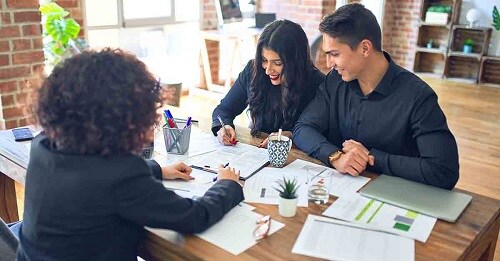 a young couple consults with a financial advisor about their bank accounts