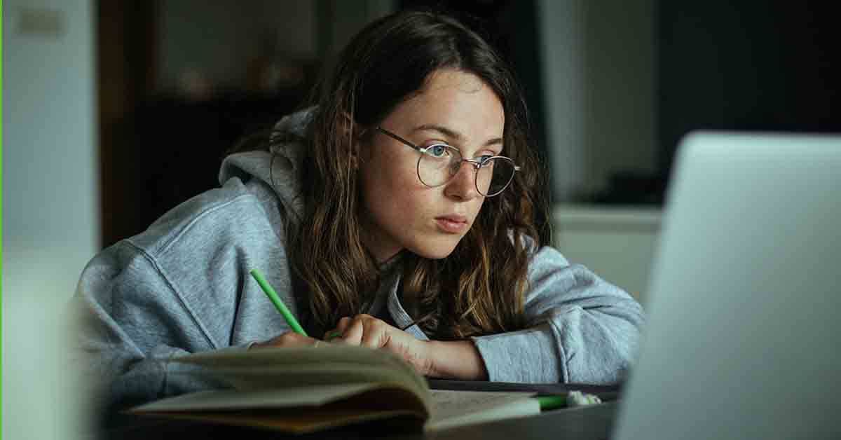 a college student studies on her laptop late at night