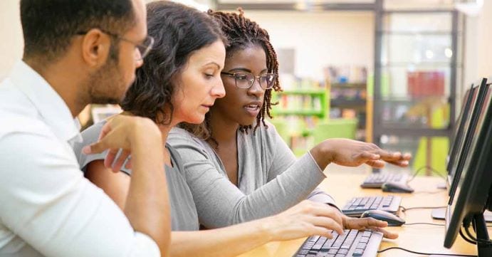 Three people looking at computer