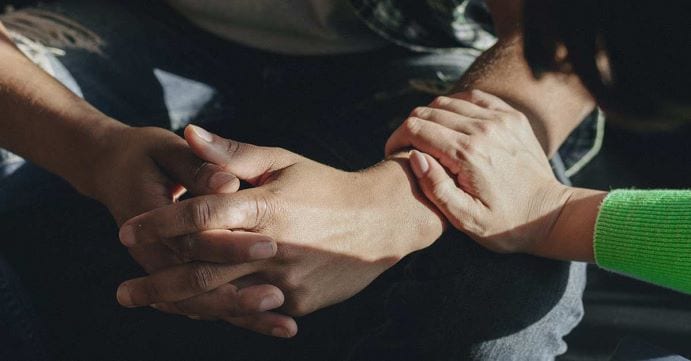 Hand resting on another person's arm