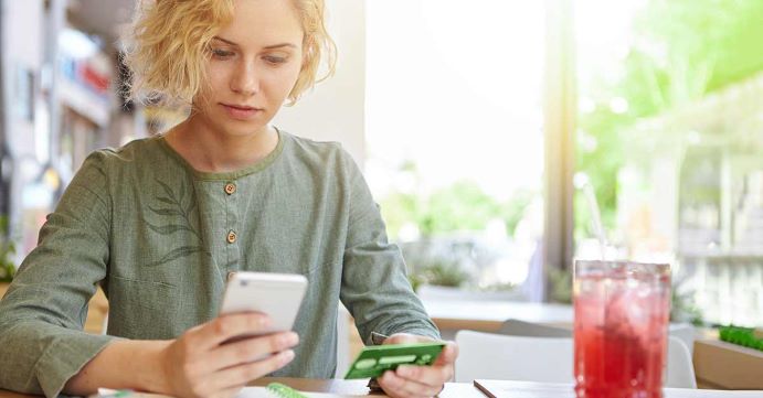 woman holding green credit card