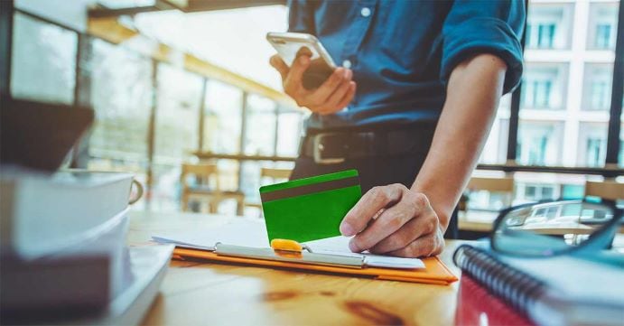Person looking at green credit card
