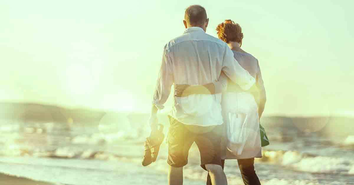 man and woman walking on the beach
