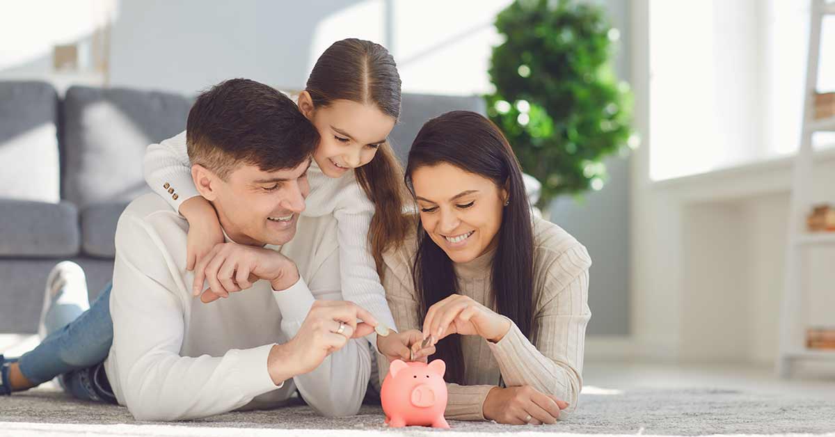 family putting money in piggy bank