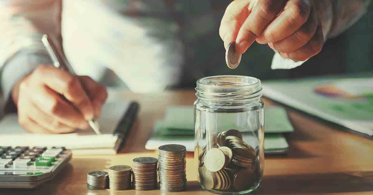 a man is about to place a coin inside a jar