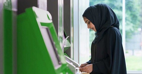 a woman cashes a check without a bank account at an atm