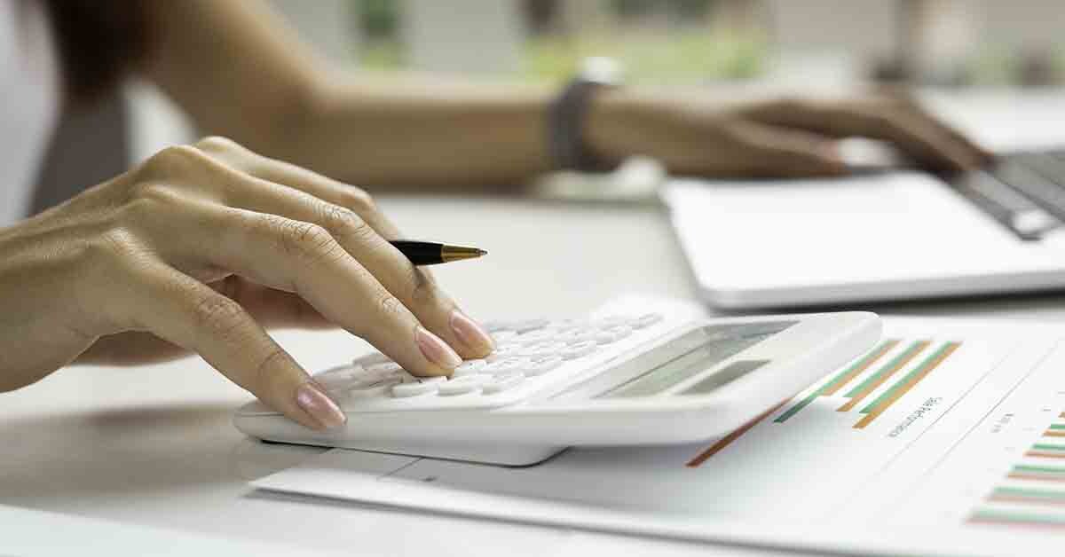 Woman types on a calculator